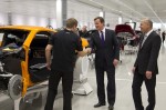 Prime Minister David Cameron meets a member of staff on the McLaren MP4-12C production line